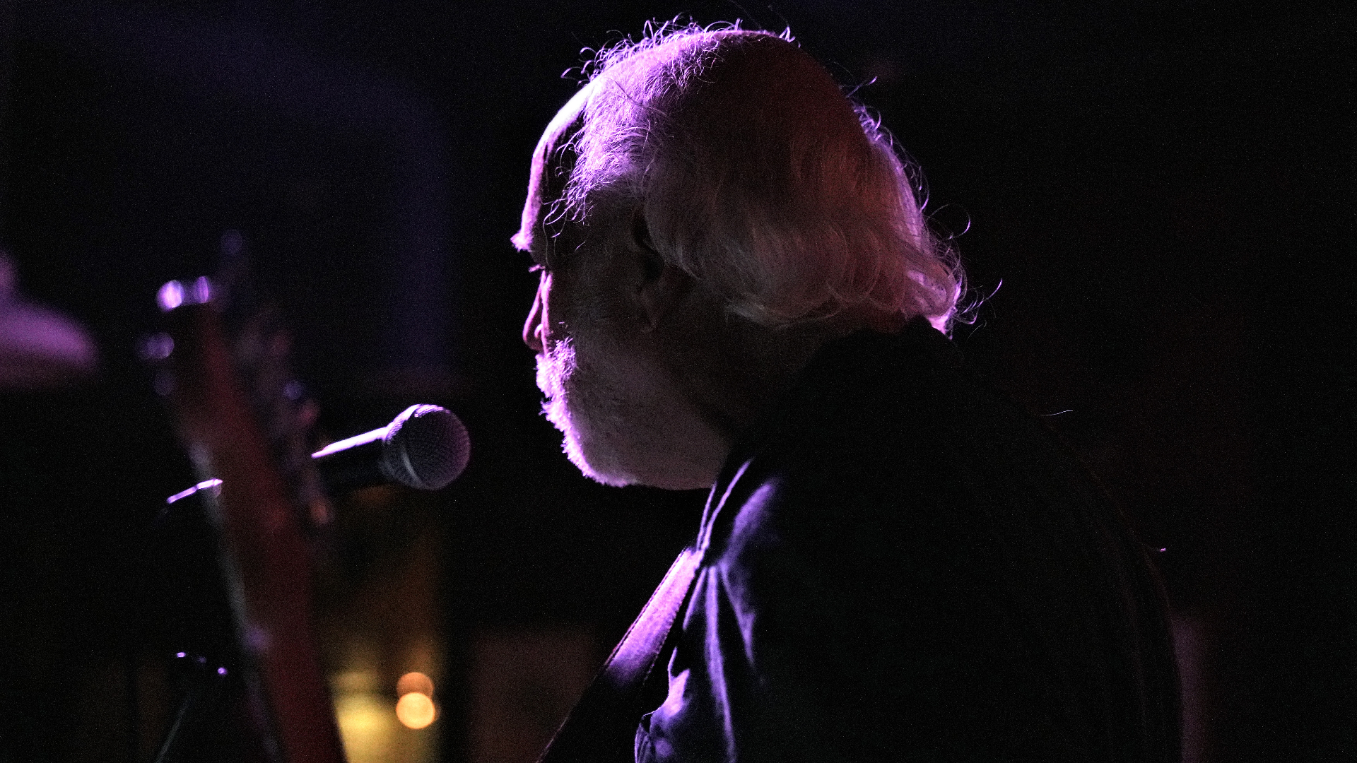 Jim silhouetted at the mic